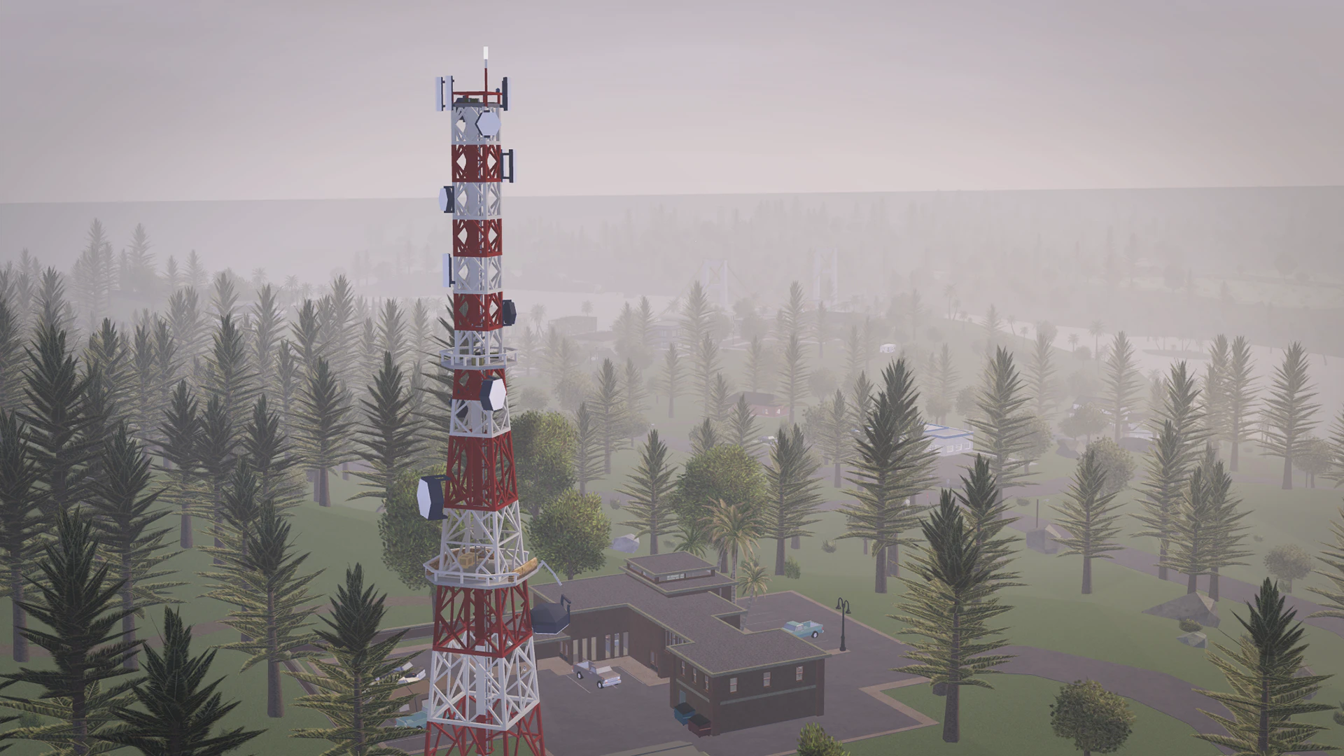 Red and white radio tower rising above a foggy pine forest